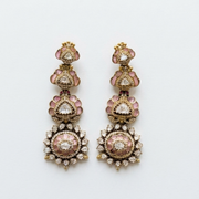 Pair of ornate earrings with pink and gold details on a white background